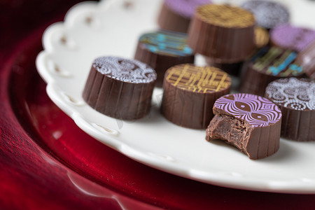 巧克力红心摄影照片_带有心形设计的精美巧克力糖上菜盘