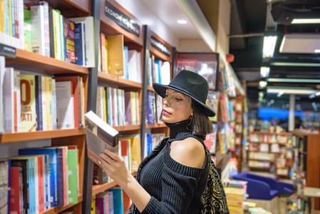 书店的人摄影照片_戴黑帽子的美女在书店