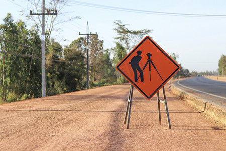 在建道路沿线放置的带有象形图测量工程的橙色标签。