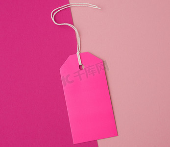 矩形标签摄影照片_彩色背景上绳子上的空粉色纸矩形标签