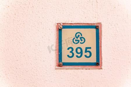 有纹理的墙上有旅馆房间号码的盘子