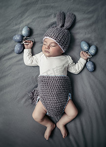 小宝宝睡着了摄影照片_可爱的小宝宝穿得像复活节兔子