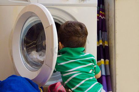 一岁半男婴把衣服放进洗衣机