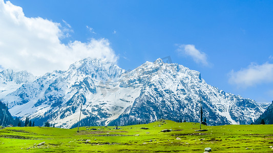 雪山岩石摄影照片_白雪皑皑的山峰和蓝天白云在 Baisaran 谷（迷你瑞士），Pahalgam，克什米尔，印度的广阔全景