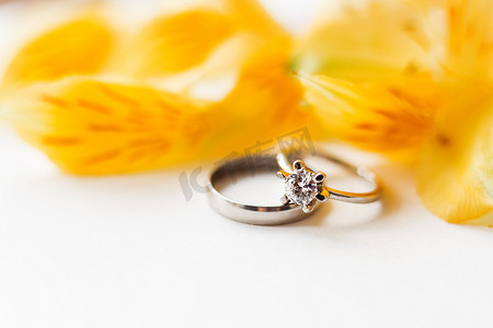 一对带有黄色六出花的结婚戒指和订婚戒指。