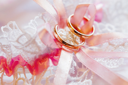 对花边织物上的金色结婚戒指。