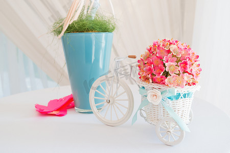 婚礼上的装饰元素-白色树枝和带花篮的装饰性小自行车。