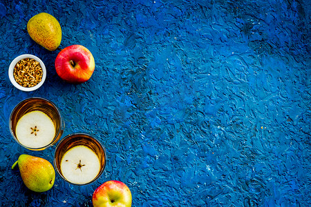 蓝色背景中带苹果和梨的果汁饮料，来自上方的复制空间