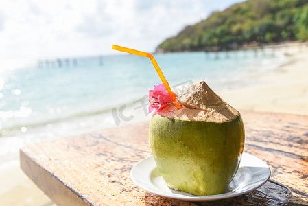 桌上椰子热带水果和沙滩背景水