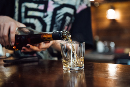 威士忌从瓶子里倒入玻璃杯
