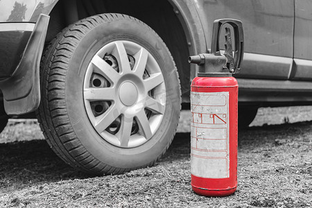 灭火器消防摄影照片_灭火器站在汽车附近的地面上作为消防安全。