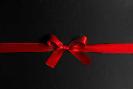蝴蝶结黑色红色摄影照片_在黑色的红色礼品蝴蝶结