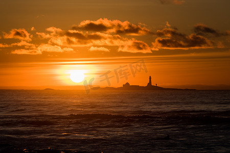 红色纱布摄影照片_与灯塔黄色红色挪威的日落 Hellsto 海滩