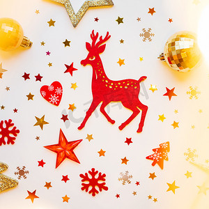 圣诞节和新年背景与闪闪发光的红色木鹿、冷杉树、心脏、雪花和五彩纸屑。