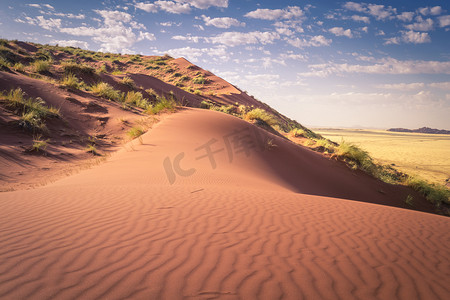 蓝宝石海报摄影照片_纳米比亚的沙丘，在阴云密布的蓝天上，在干燥和干旱的沙子中显示出波浪