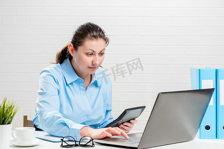 办公室里的女人用计算器从事会计工作