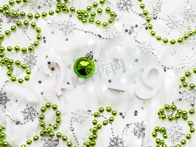 圣诞节和新年背景与数字 2019，银色和绿色装饰品和灯泡。