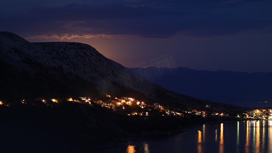 月光下的夜景，从克罗地亚的岩石山到亚得里亚海沿岸的城市，不同的色调