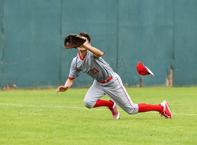 运动男孩摄影照片_打棒球的年轻运动男孩