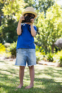 击摄影照片_点击相机中的照片的小男孩