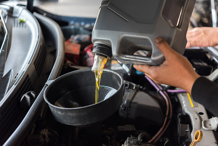 汽车修理工装满新鲜的润滑油机油