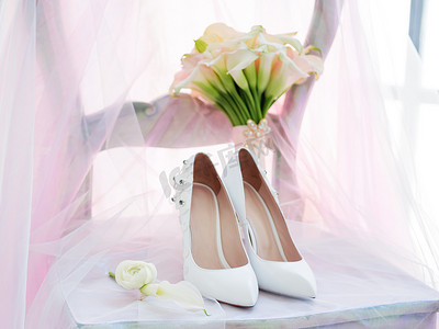 白鞋和马蹄莲的新娘花束。