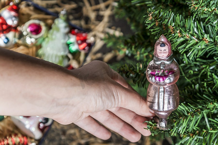 Hand hanging up his on the Christmas tree 圣诞树装饰