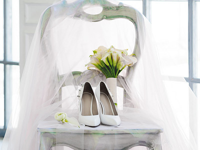 白鞋摄影照片_白鞋、闪闪发光的面纱和马蹄莲的新娘花束。