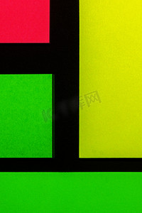 小麻薯贴纸摄影照片_黑纸上的绿色、黄色和玫瑰色彩色办公贴纸。 
