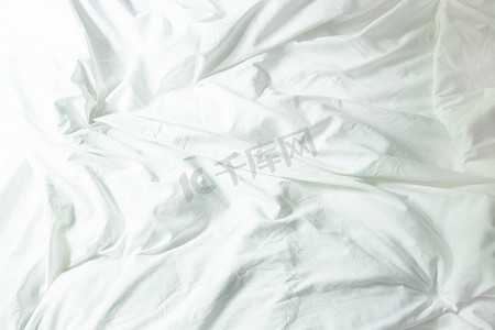 床上的白色枕头和卧室里皱巴巴的凌乱毯子，F