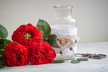 红色花卉邀请函摄影照片_与花瓶的葡萄酒新鲜的红色庭院玫瑰。
