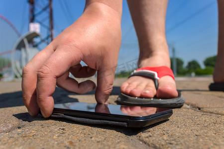 一个男人在落在路上的公园里举起智能手机