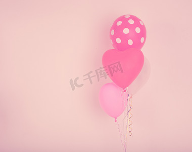 气球装饰背景墙摄影照片_粉红色墙上的快速心形气球，带有老式过滤器 ef