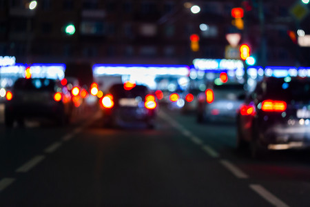 夜间街道汽车交通的散焦图片-从道路看。