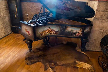 背景立绘摄影照片_一架古老的钢琴立在动物的皮肤上，侧面绘有图画