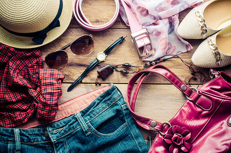 度假少女的配饰、帽子、时尚的夏季太阳镜、皮包、鞋子和木地板上的服装。