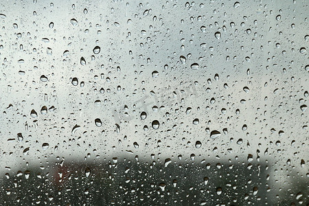 窗玻璃质地上的水滴新鲜凝结，雨季湿背景冷却感觉和寒冷，雨滴质地湿透明气泡