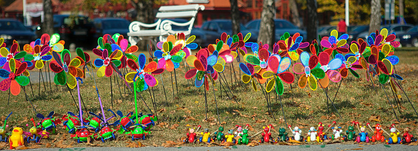 田野上一堆五颜六色的儿童风车玩具