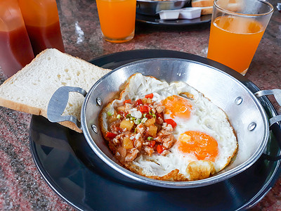 面包鸡蛋橙汁摄影照片_煎鸡蛋配配料、面包和橙汁。