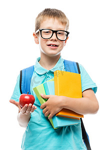 背包展示摄影照片_拿着书的小学生在白色的 ba 上午餐时展示了一个红苹果