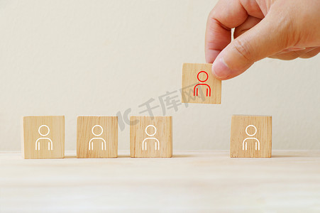木制立方体上的人物图标，用手挑选与他们不同。