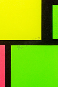 黑纸上的绿色、黄色和玫瑰色彩色办公贴纸。 