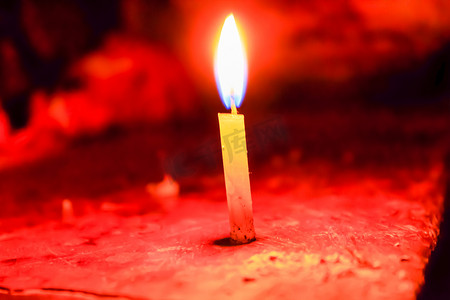 光明节摄影照片_在印度的传统庆祝活动排灯节中，一根圣诞蜡烛在黑色背景上散发出光芒。