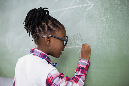 女学生在课堂上在黑板上做数学