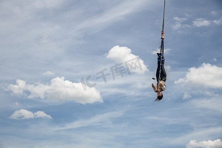斯海文宁根，2019 年 6 月 2 日 — 蹦极跳台从悬挂在起重机上的平台跳入水中，映衬着荷兰海牙纯蓝色的春日天空
