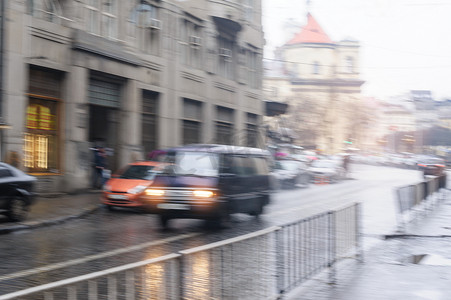 雨中汽车摄影照片_汽车在雨中沿着街道行驶。