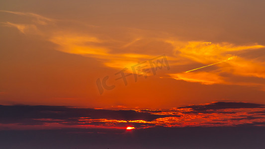 在五颜六色、明亮的橙色日落期间的天空，太阳光线穿过云层
