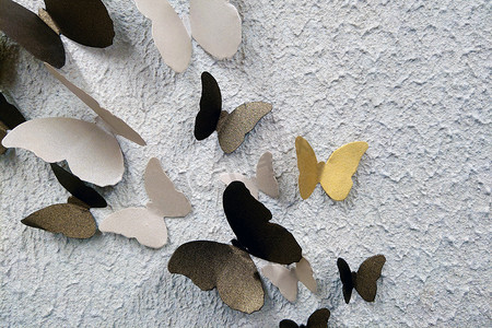 装饰蝴蝶摄影照片_建筑物墙壁背景上的装饰蝴蝶。
