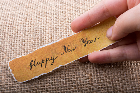 手拿一张撕破的纸写的新年快乐