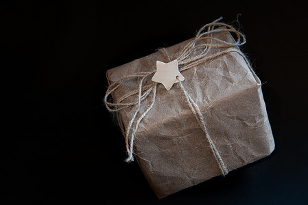 黑色背景牛皮纸礼品盒，中心为标签或文字